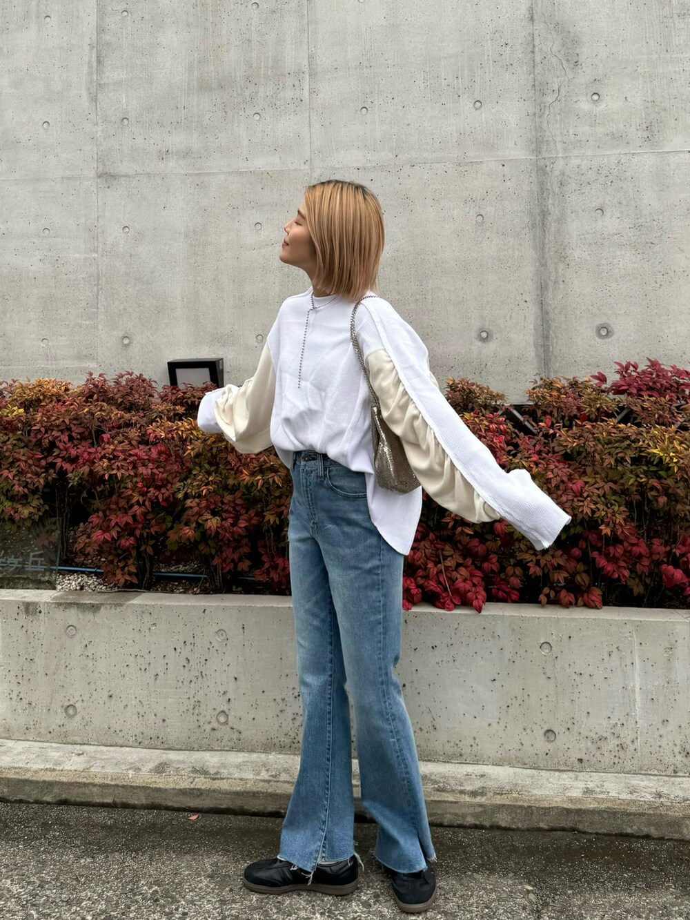 ホワイト系のTシャツ/カットソー、ブルー系のデニムパンツ、ブラック系のスニーカーを着用したレディースの冬コーディネートの5枚目の写真