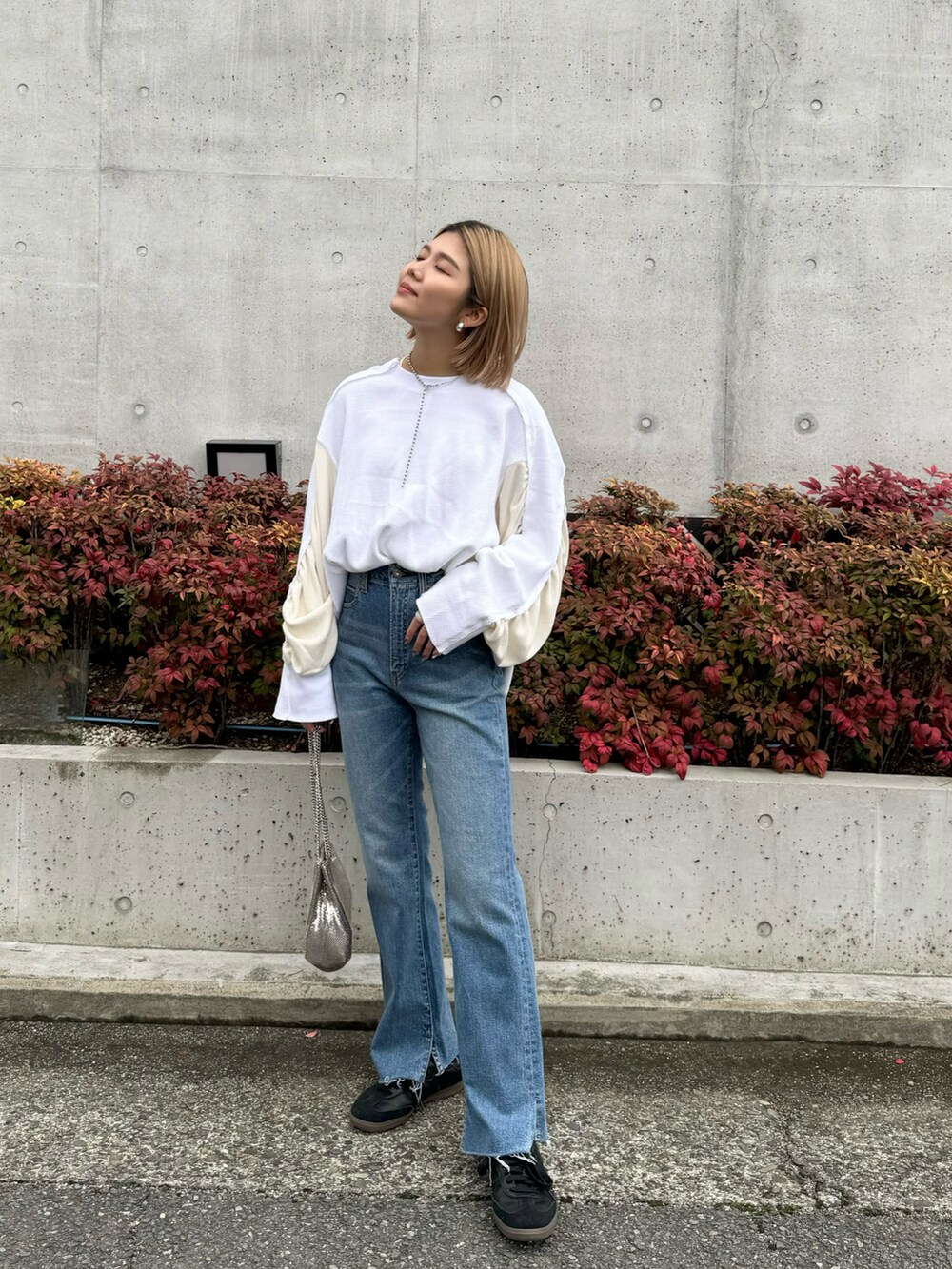 ホワイト系のTシャツ/カットソー、ブルー系のデニムパンツ、ブラック系のスニーカーを着用したレディースの冬コーディネートの2枚目の写真
