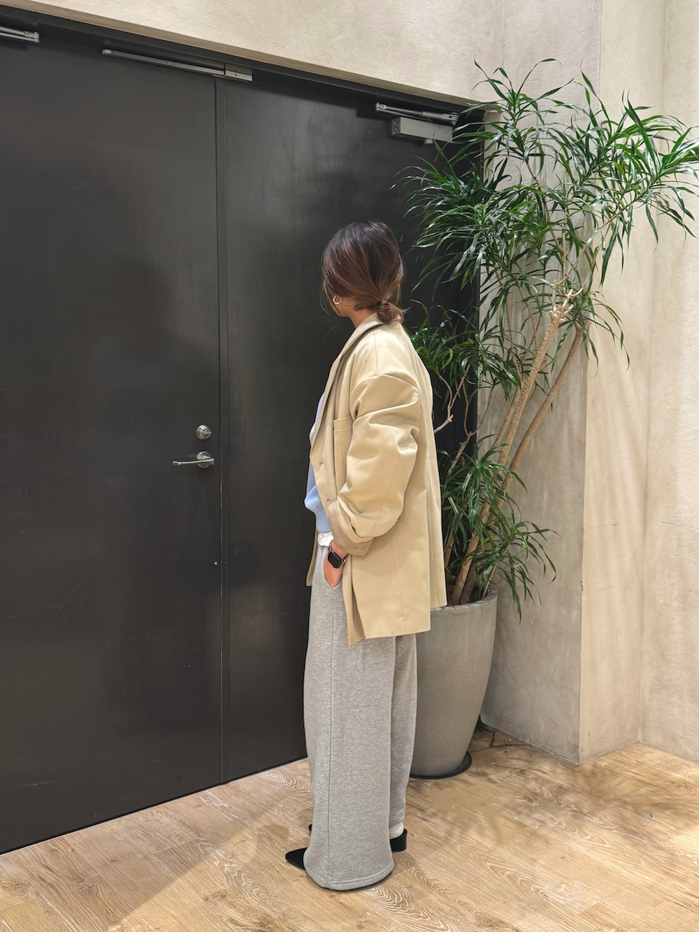 ブルー系のニット/セーター、ベージュ系のテーラードジャケット、ブラック系のショルダーバッグを着用したレディースの冬コーディネートの2枚目の写真