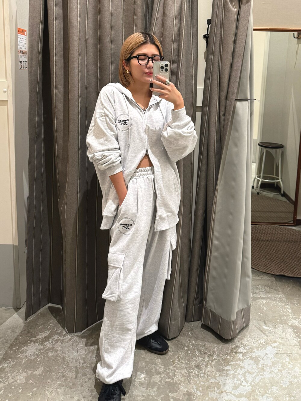グレー系のパーカー、グレー系のスウェットパンツ、ブラック系のスニーカーを着用したレディースの冬コーディネートの2枚目の写真