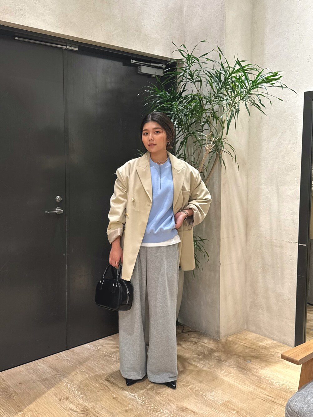 ブルー系のニット/セーター、ベージュ系のテーラードジャケット、ブラック系のショルダーバッグを着用したレディースの冬コーディネートの3枚目の写真