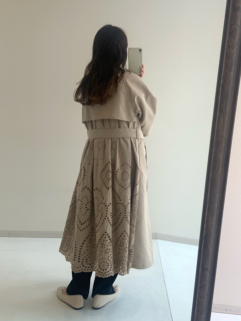 ホワイト系のTシャツ/カットソー、ベージュ系のトレンチコート、ブラック系のパンツを着用したレディースの冬コーディネートの2枚目の写真