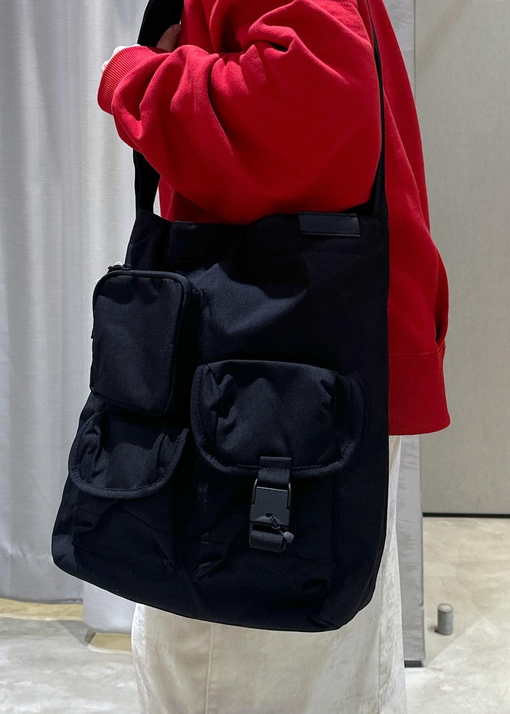 ブラック系のブーツ、ホワイト系のスカート、レッド系のスウェットを着用したレディースの冬コーディネートの6枚目の写真