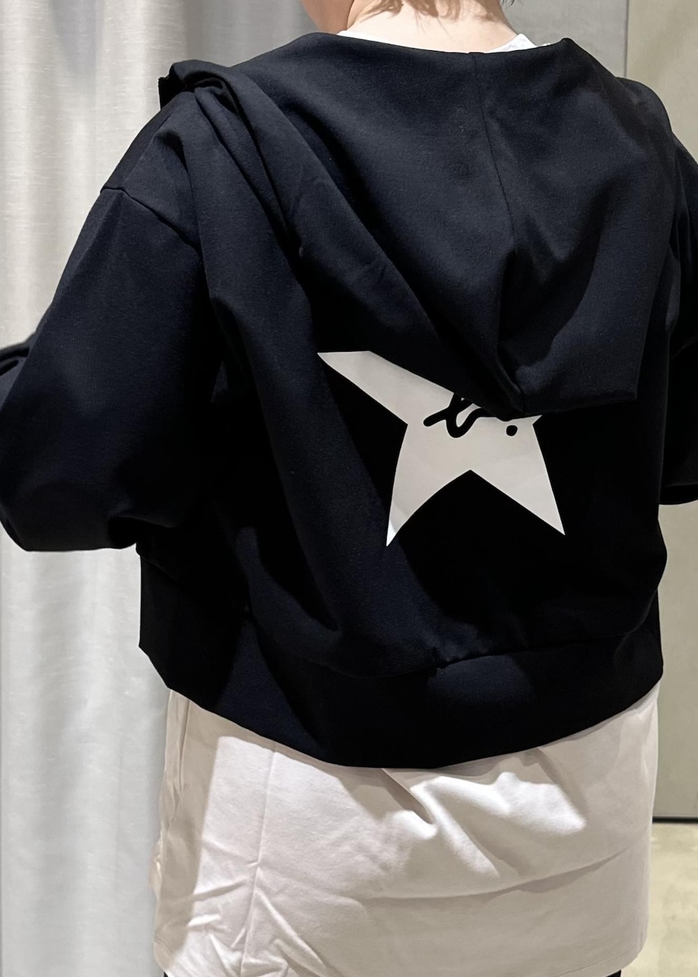 ブラック系のパーカー、ベージュ系のTシャツ/カットソー、ブラック系のスニーカーを着用したレディースの冬コーディネートの4枚目の写真