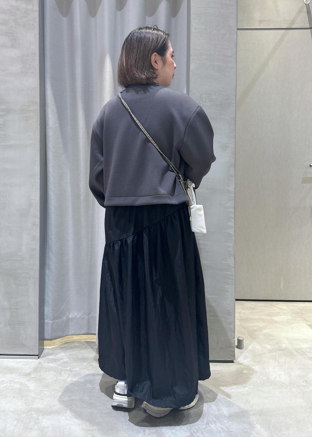 ホワイト系のスニーカー、ホワイト系のショルダーバッグ、ブラック系のワンピースを着用したレディースの秋コーディネートの3枚目の写真