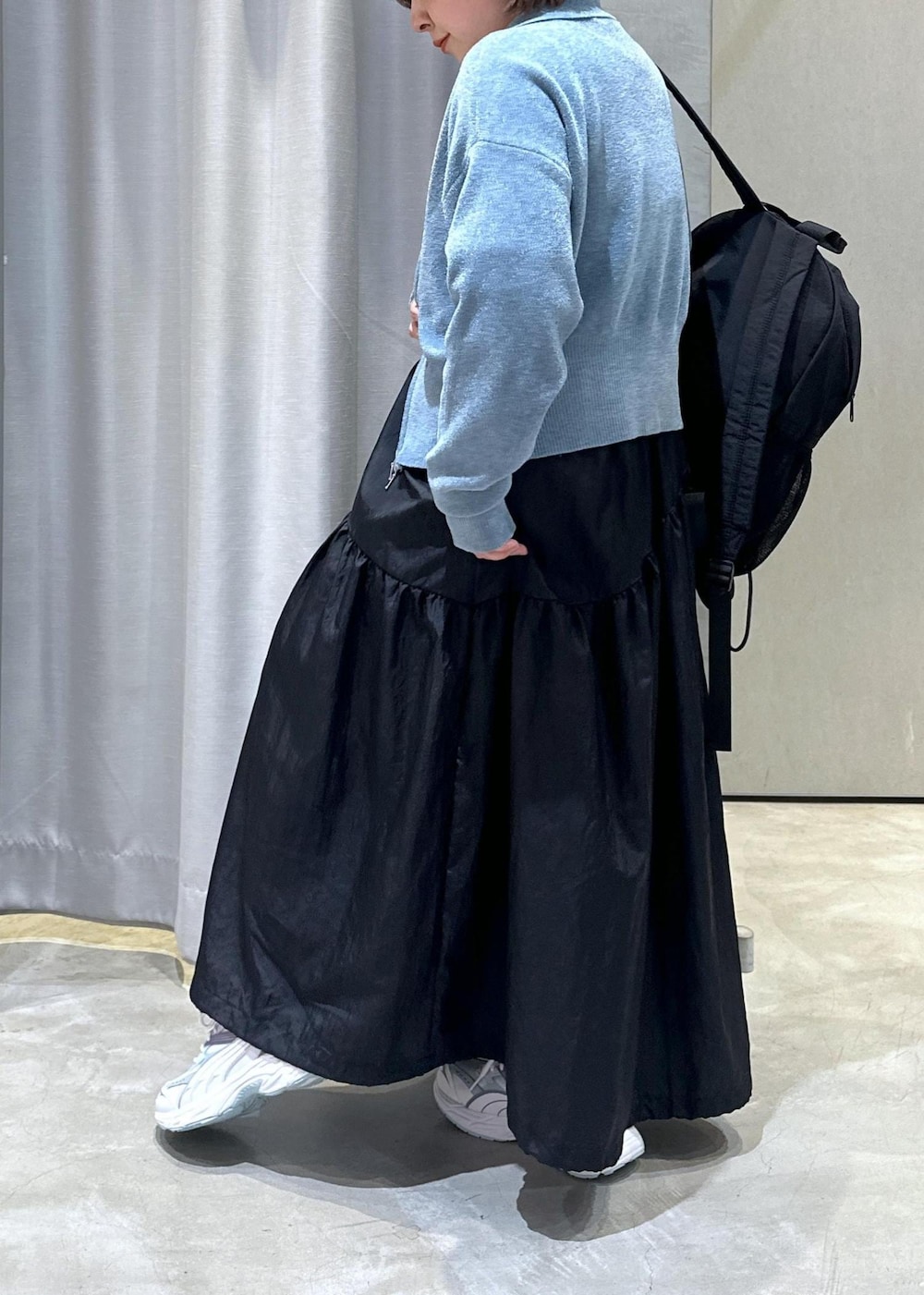 ブラック系のバックパック/リュック、ブラック系のワンピース、ブルー系のカーディガン/ボレロを着用したレディースの秋コーディネートの4枚目の写真