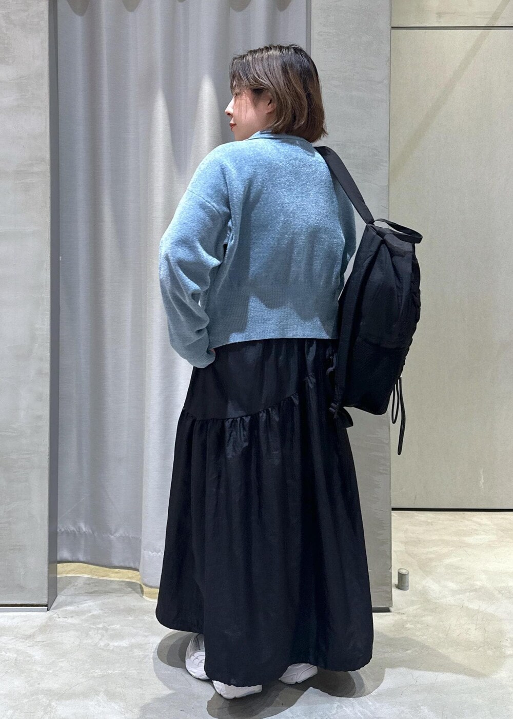 ブラック系のバックパック/リュック、ブラック系のワンピース、ブルー系のカーディガン/ボレロを着用したレディースの秋コーディネートの3枚目の写真