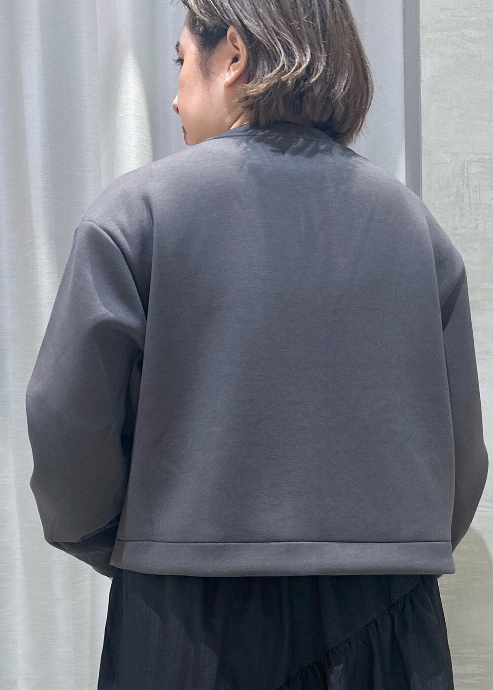 ホワイト系のスニーカー、ホワイト系のショルダーバッグ、ブラック系のワンピースを着用したレディースの秋コーディネートの4枚目の写真