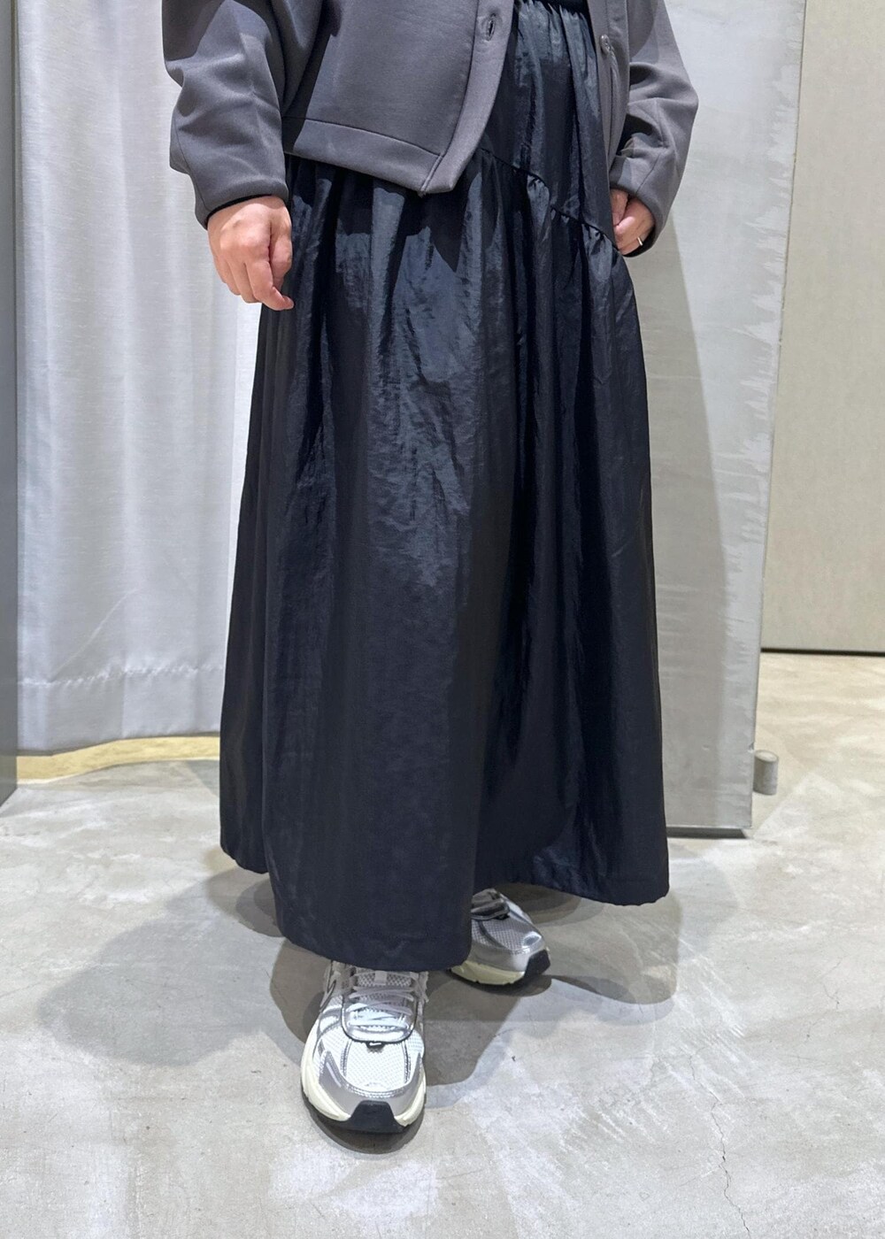 ホワイト系のスニーカー、ホワイト系のショルダーバッグ、ブラック系のワンピースを着用したレディースの秋コーディネートの7枚目の写真