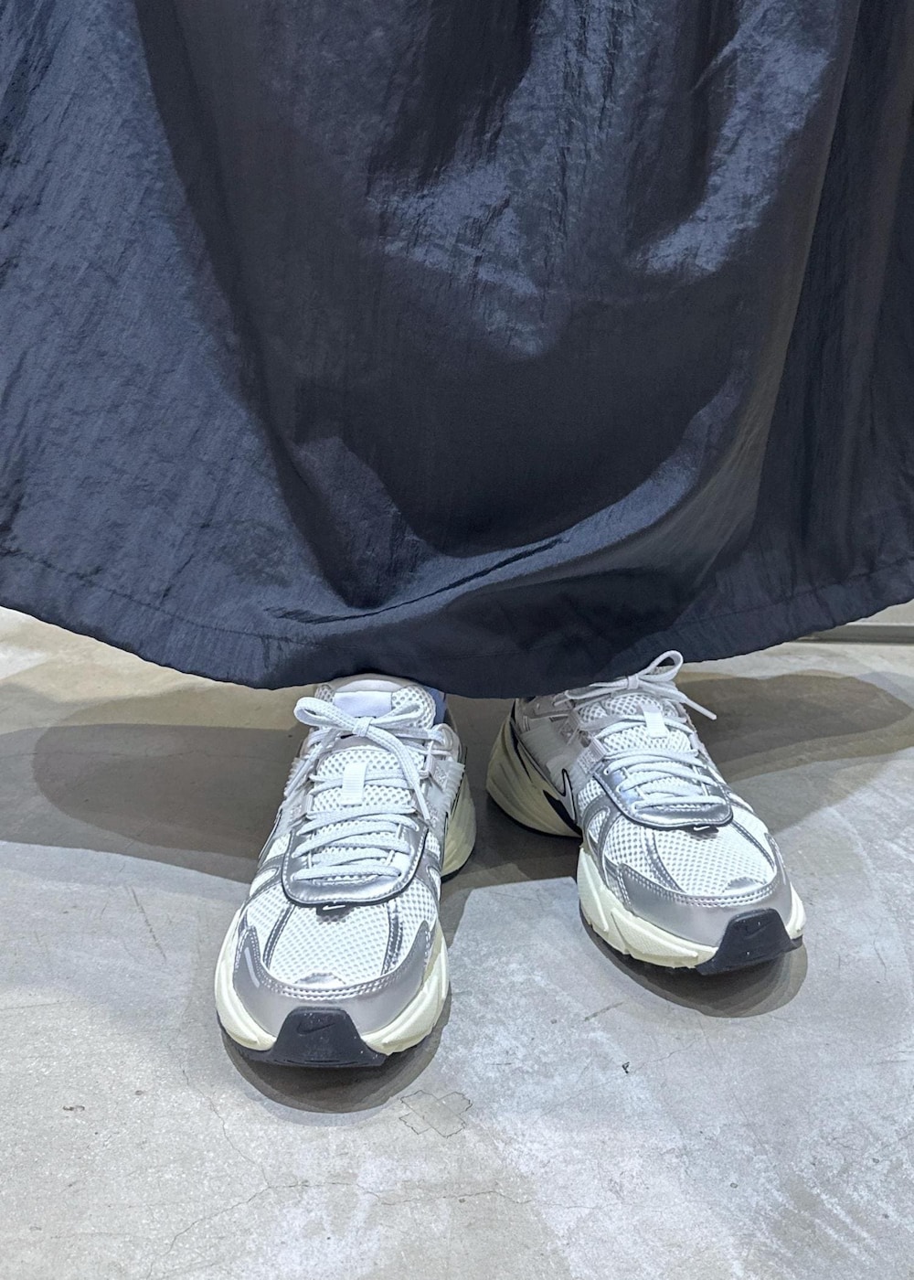 ホワイト系のスニーカー、ホワイト系のショルダーバッグ、ブラック系のワンピースを着用したレディースの秋コーディネートの8枚目の写真