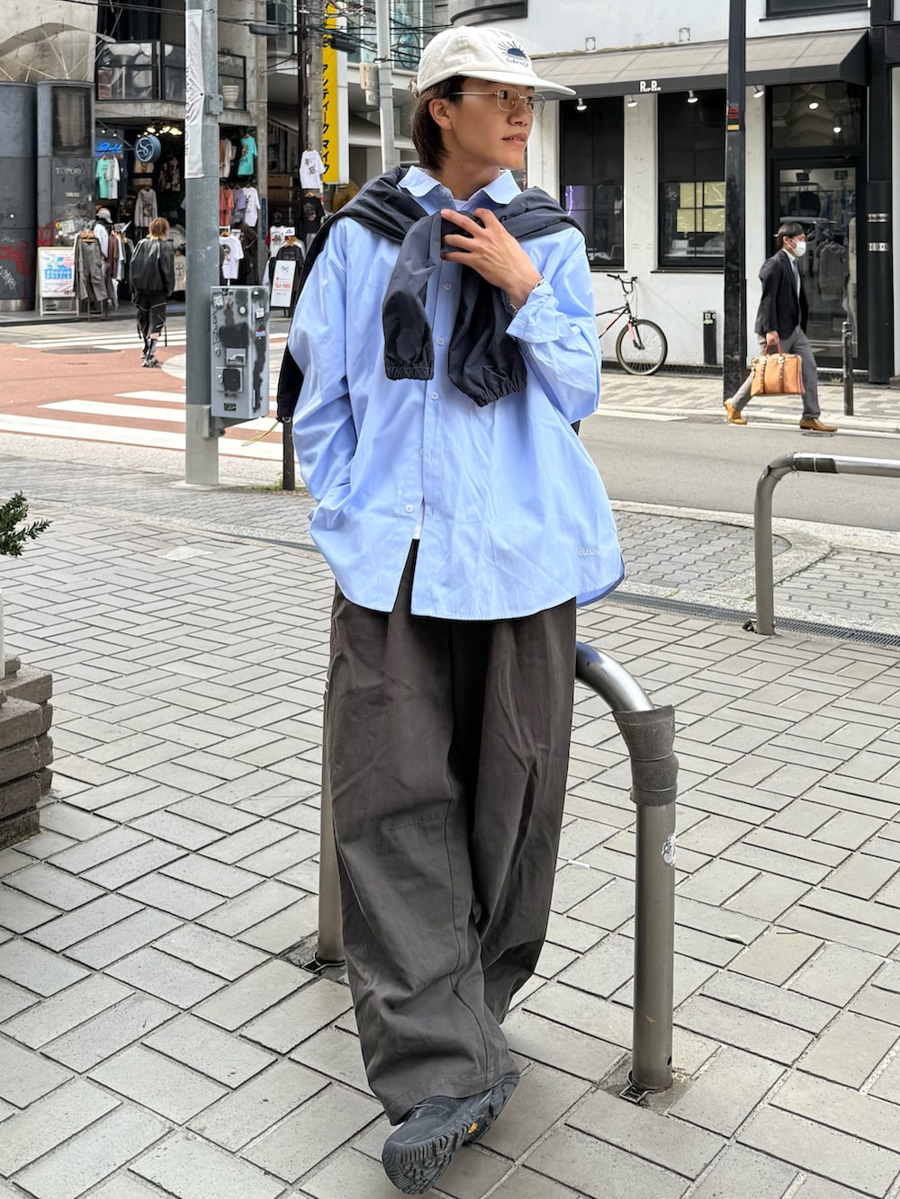 ブラック系のスニーカー、グレー系のチノパンツ、ブルー系のシャツ/ブラウスを着用したメンズの春コーディネートの2枚目の写真