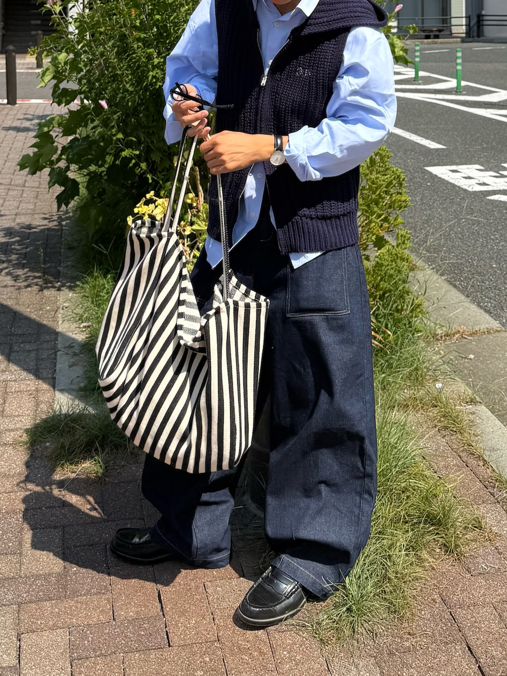 ブルー系のシャツ/ブラウス、ブルー系のデニムパンツ、ブラック系のトートバッグを着用したメンズの秋コーディネートの2枚目の写真