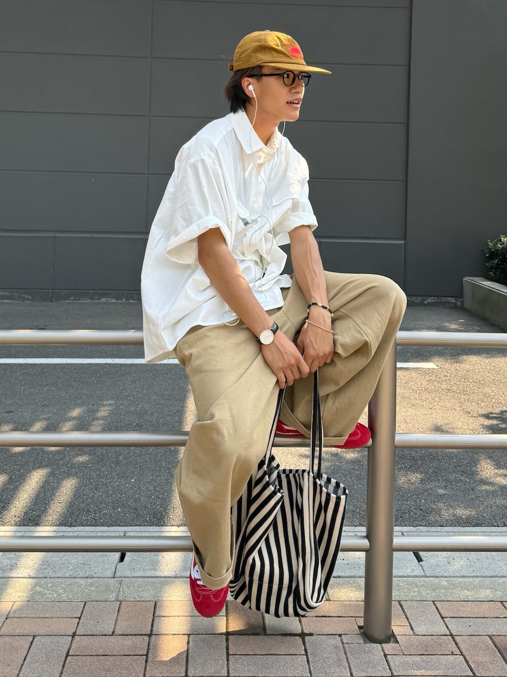 ベージュ系のチノパンツ、レッド系のスニーカー、ホワイト系のシャツ/ブラウスを着用したメンズの夏コーディネートの2枚目の写真