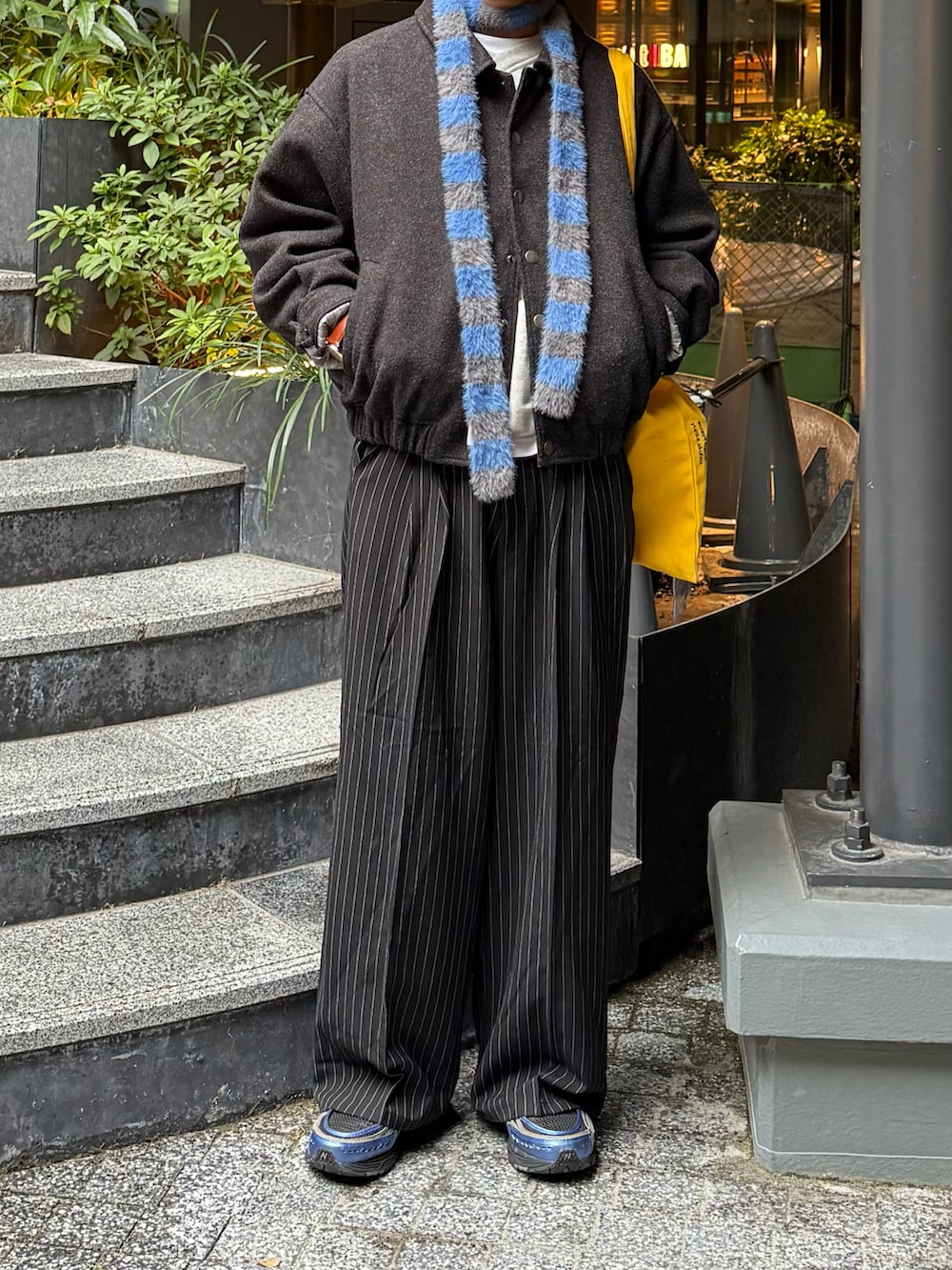 グレー系のスウェット、ブラック系のブルゾン、ブラック系のスラックスを着用したメンズの冬コーディネートの2枚目の写真