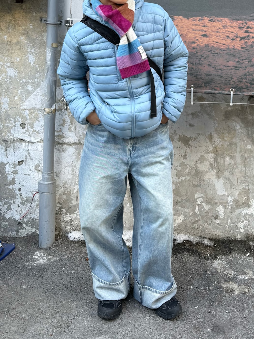 ブルー系のデニムパンツ、ブラック系のスニーカー、その他のダウンジャケット/コートを着用したメンズの冬コーディネートの2枚目の写真