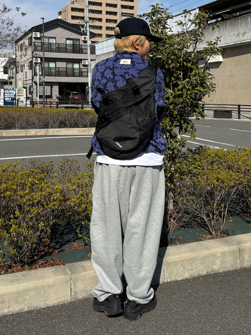 ブラック系のスニーカー、ブラック系のボディバッグ/ウエストポーチ、ブルー系のその他アウターを着用したメンズの冬コーディネートの2枚目の写真