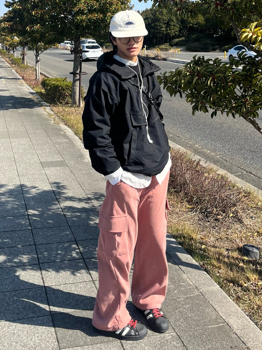 ブラック系のスニーカー、ピンク系のカーゴパンツ、ブラック系のジャケット/アウターを着用したメンズの冬コーディネートの2枚目の写真