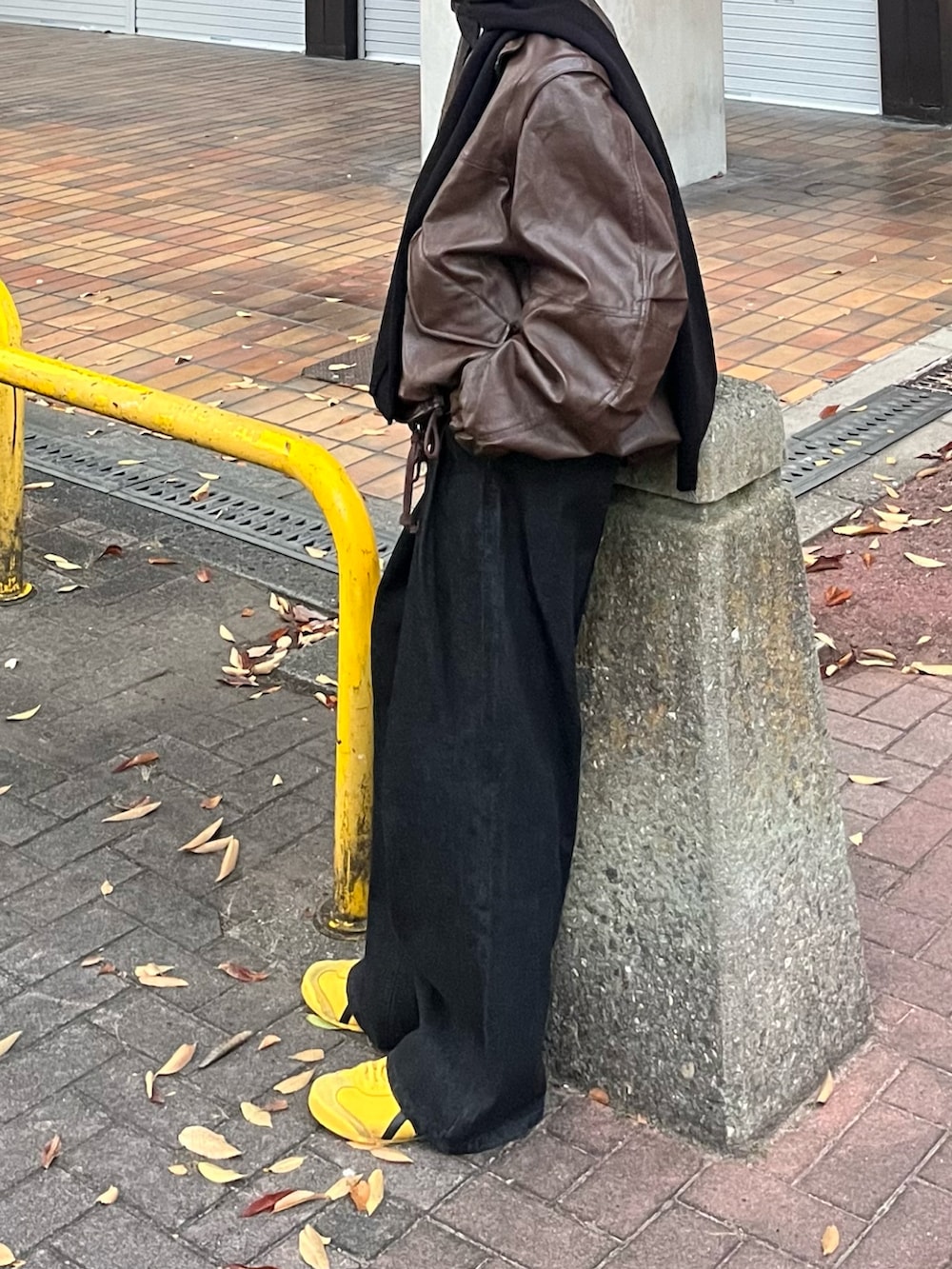 ブラウン系のブルゾン、ブラック系のデニムパンツ、イエロー系のスニーカーを着用したメンズの秋コーディネートの2枚目の写真