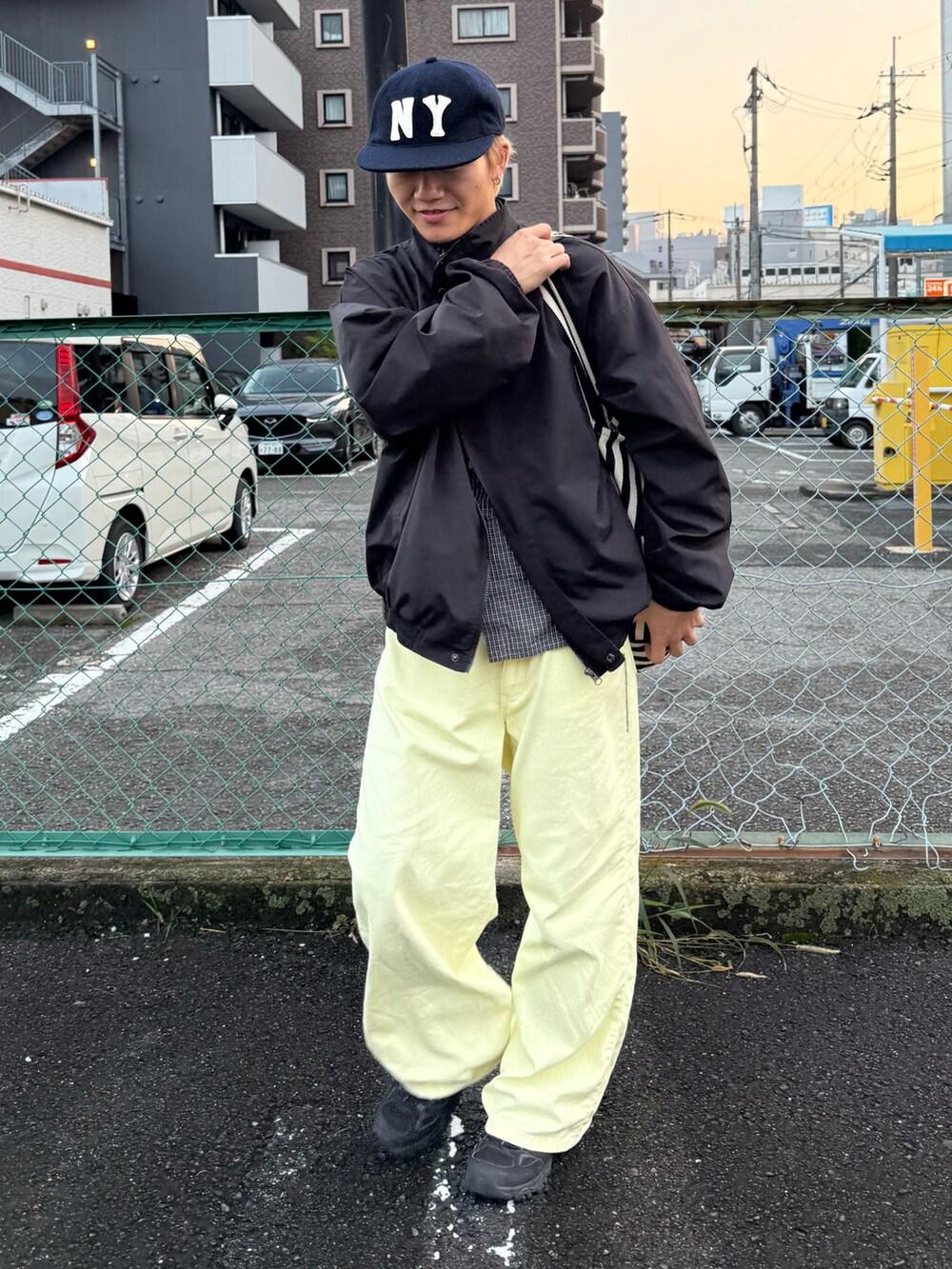 ブラック系のスニーカー、ブラック系のトートバッグ、イエロー系のその他パンツを着用したメンズの冬コーディネートの2枚目の写真