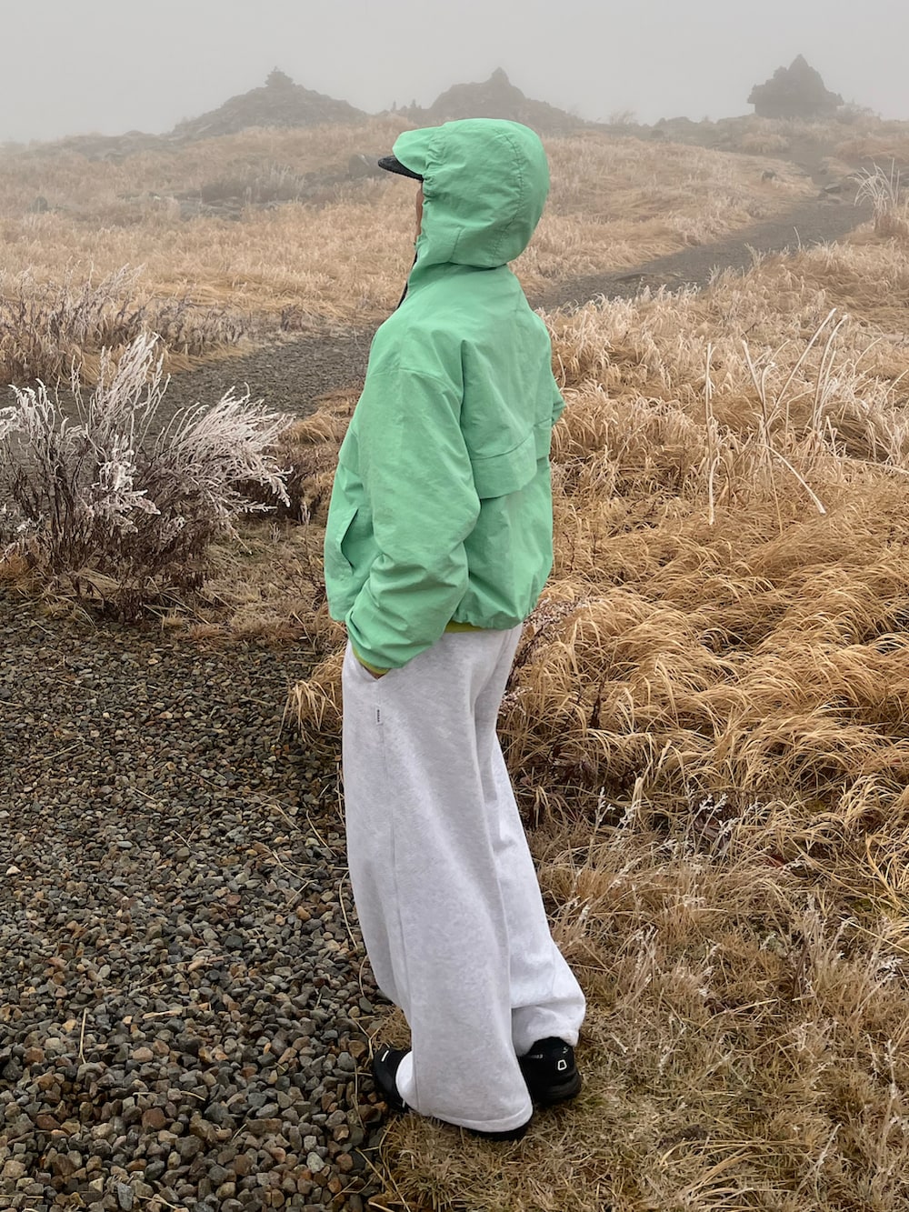 グレー系のスウェットパンツ、ブラック系のスニーカー、ブルー系のナイロンジャケットを着用したメンズの秋コーディネートの2枚目の写真