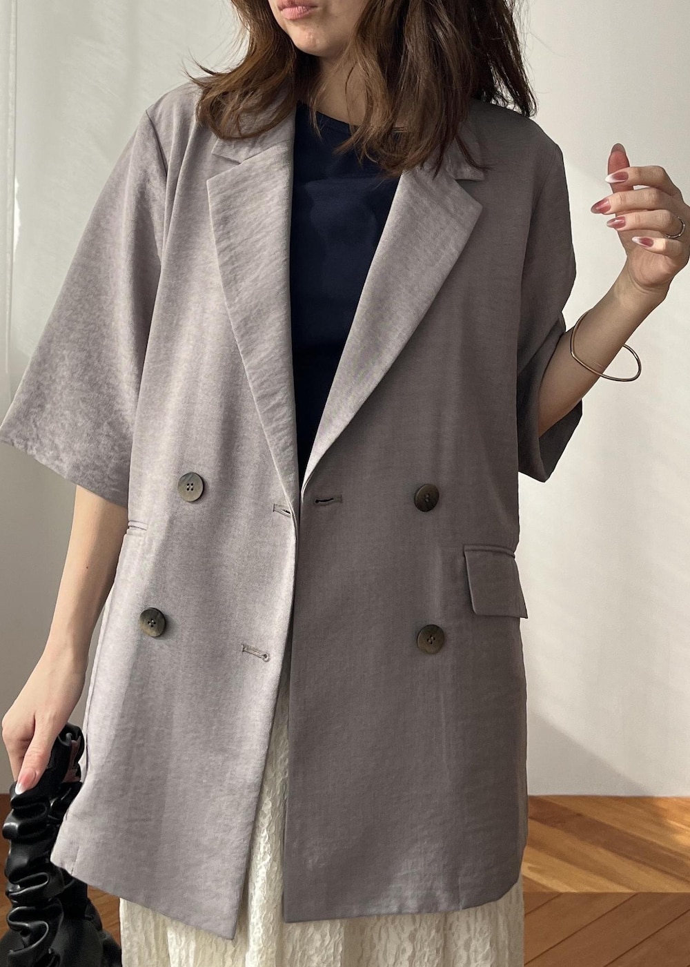 ホワイト系のスカート、ブラック系のショルダーバッグ、ホワイト系のサンダルを着用したレディースの春コーディネートの10枚目の写真