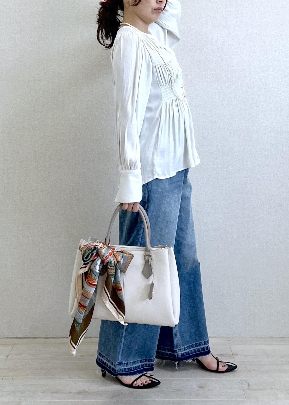 ブラック系のキャミソール、ブルー系のデニムパンツ、ブラック系のカーディガン/ボレロを着用したレディースの春コーディネートの9枚目の写真