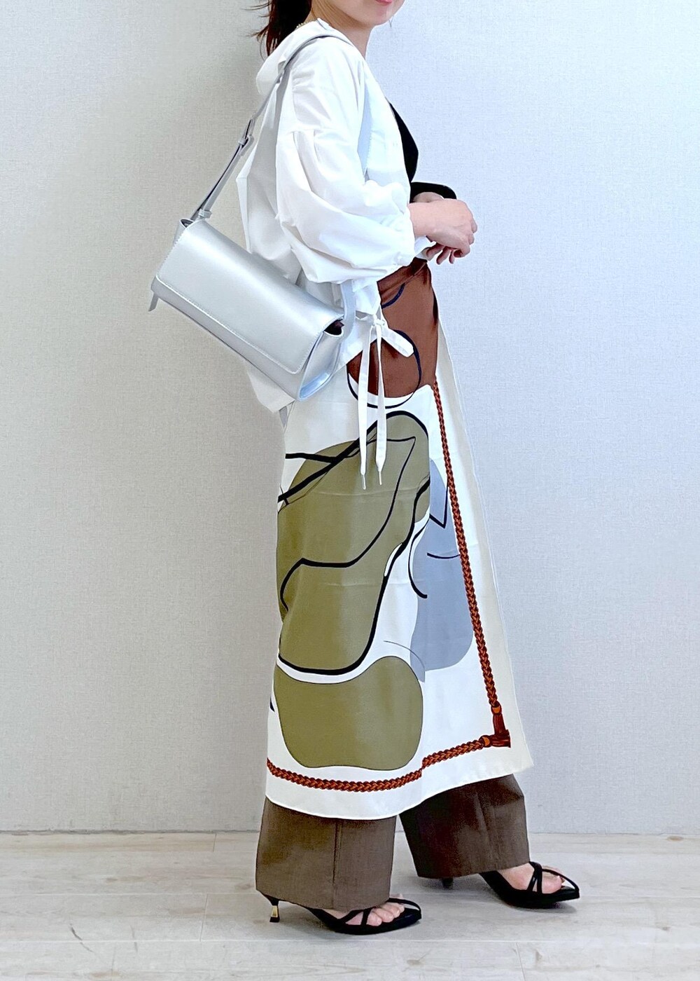 ブラック系のキャミソール、シルバー系のショルダーバッグ、ブラック系のサンダルを着用したレディースの春コーディネートの2枚目の写真