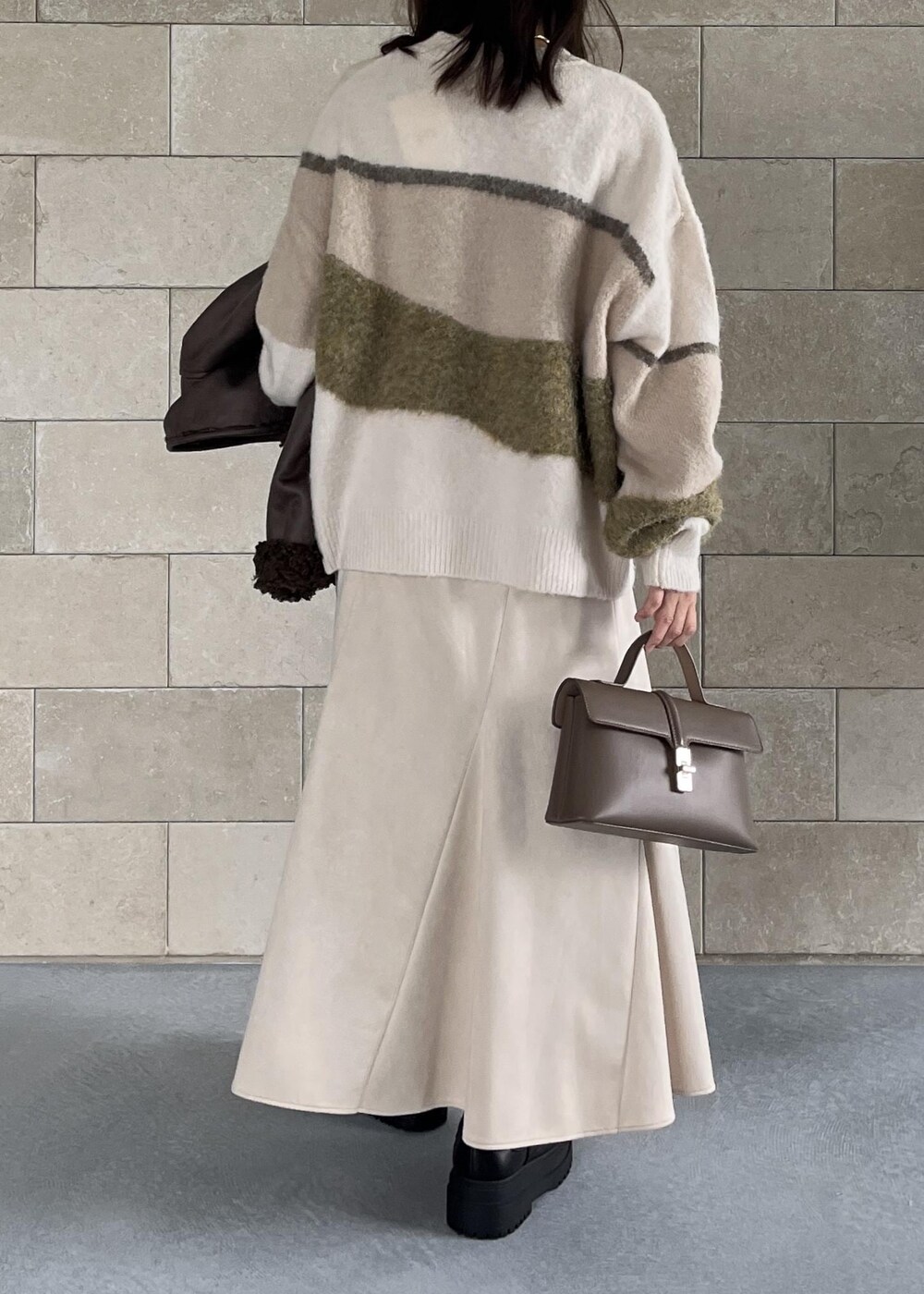 ベージュ系のショルダーバッグ、ブラック系のブーツ、ブラウン系のブルゾンを着用したレディースの秋コーディネートの9枚目の写真