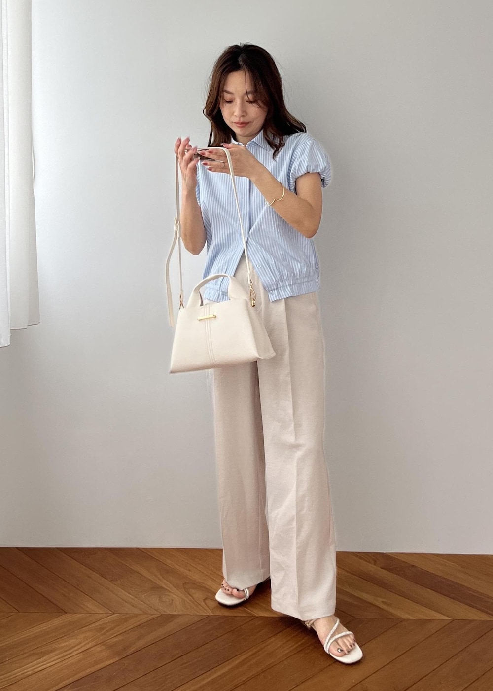 ホワイト系のその他パンツ、ホワイト系のショルダーバッグ、ホワイト系のサンダルを着用したレディースの春コーディネートの6枚目の写真