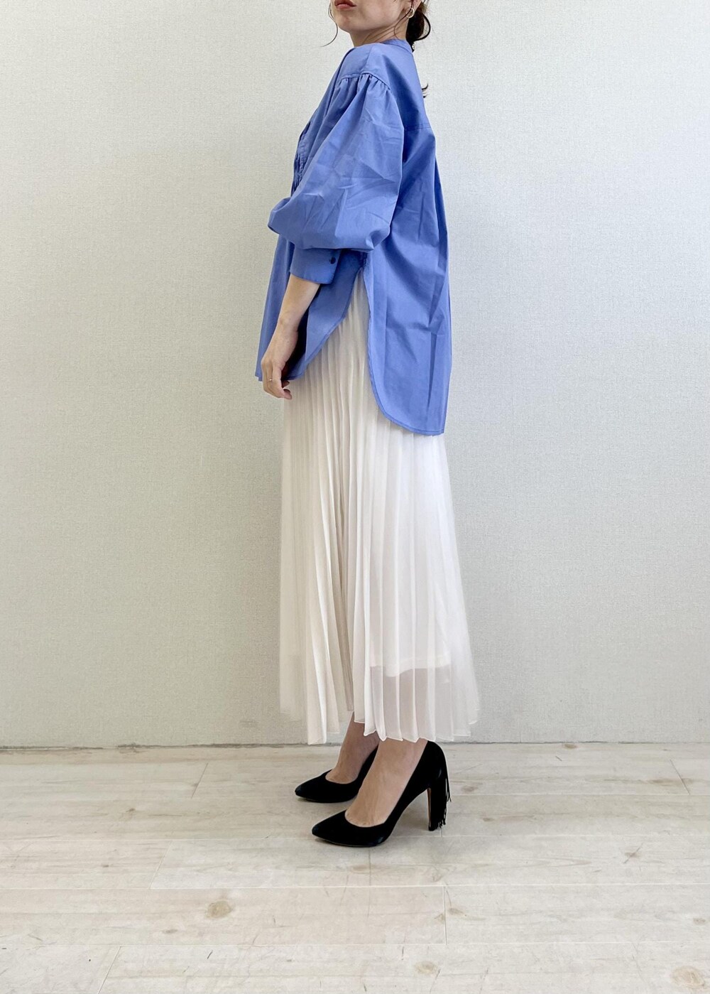 ブラック系のショルダーバッグ、ブルー系のシャツ/ブラウス、ホワイト系のスカートを着用したレディースの春コーディネートの2枚目の写真