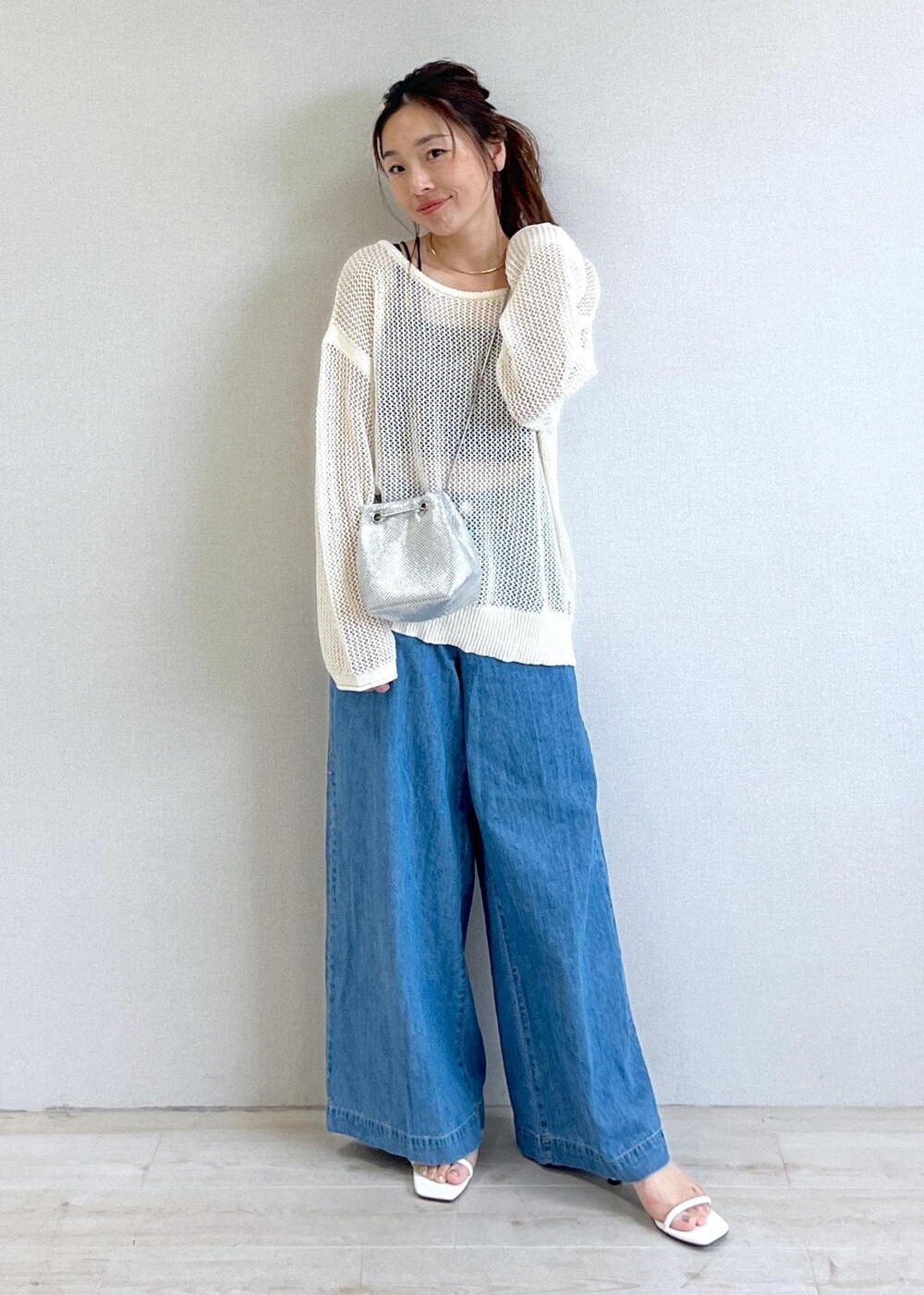 ホワイト系のサンダル、ブラック系のキャミソール、ブルー系のデニムパンツを着用したレディースの夏コーディネートの5枚目の写真