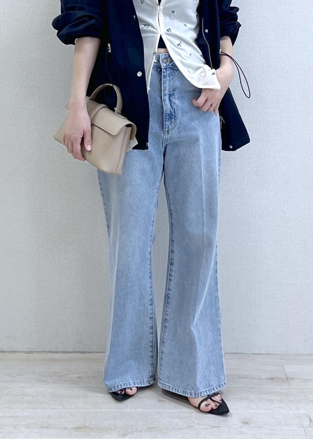 ベージュ系のショルダーバッグ、ブルー系のナイロンジャケット、ブラック系のキャミソールを着用したレディースの春コーディネートの6枚目の写真