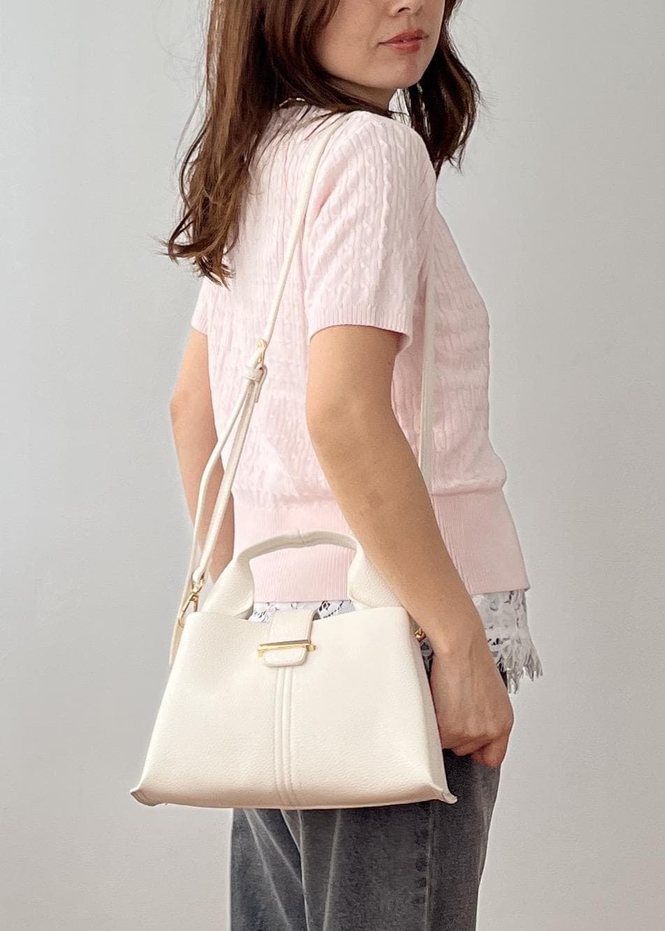 ホワイト系のキャミソール、ブラック系のデニムパンツ、ホワイト系のショルダーバッグを着用したレディースの春コーディネートの6枚目の写真