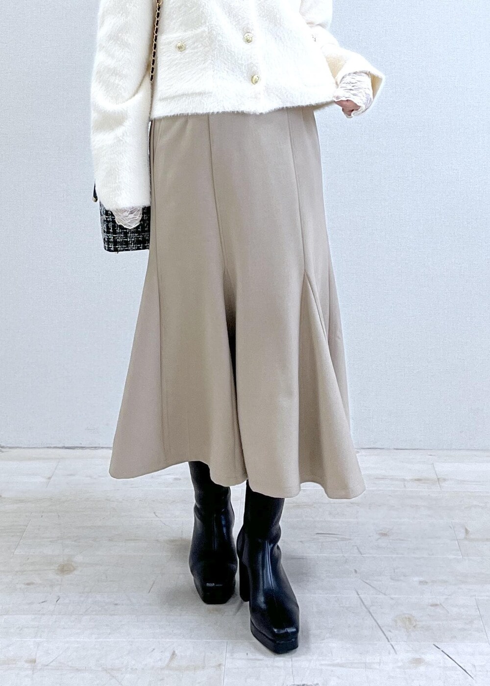 ベージュ系のスカート、ホワイト系のカーディガン/ボレロ、ホワイト系のTシャツ/カットソーを着用したレディースの秋コーディネートの8枚目の写真