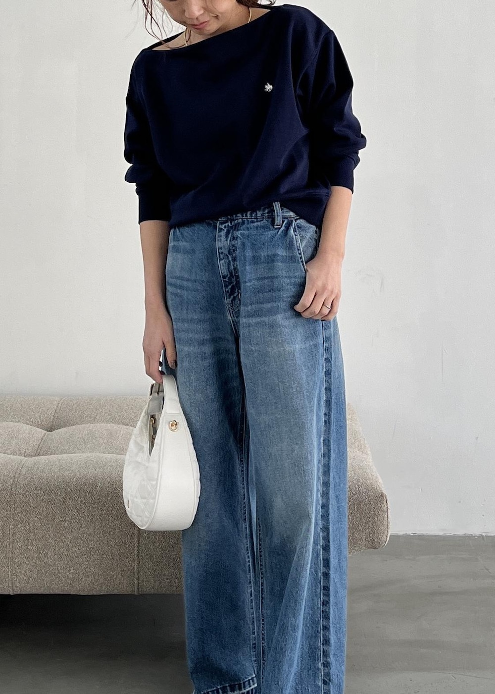 ホワイト系のハンドバッグ、ブラック系のパンプス、ブルー系のデニムパンツを着用したレディースの冬コーディネートの7枚目の写真