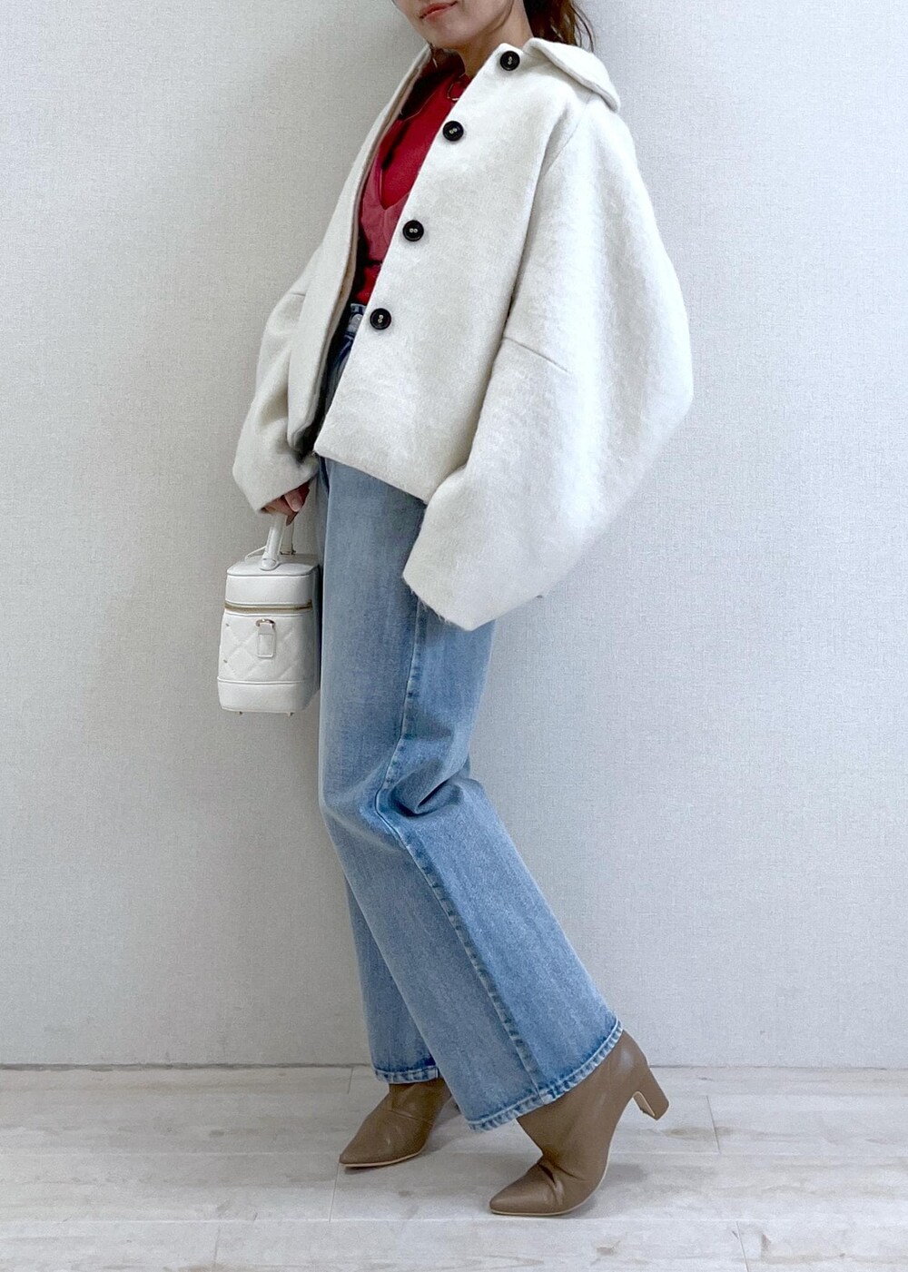 ベージュ系のブーツ、ホワイト系のその他アウター、ブルー系のデニムパンツを着用したレディースの秋コーディネートの2枚目の写真