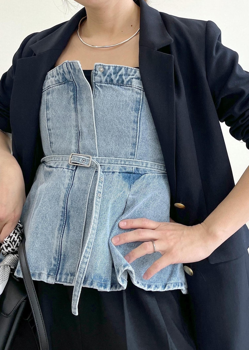 ブラック系のショルダーバッグ、ブルー系のキャミソール、ブルー系のスラックスを着用したレディースの冬コーディネートの5枚目の写真