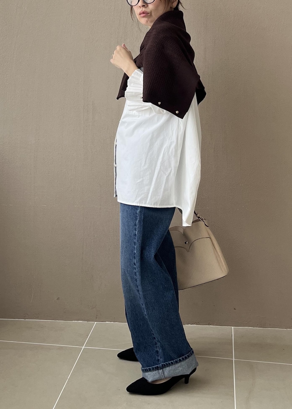 ホワイト系のシャツ/ブラウス、ベージュ系のショルダーバッグ、ブルー系のデニムパンツを着用したレディースの夏コーディネートの3枚目の写真