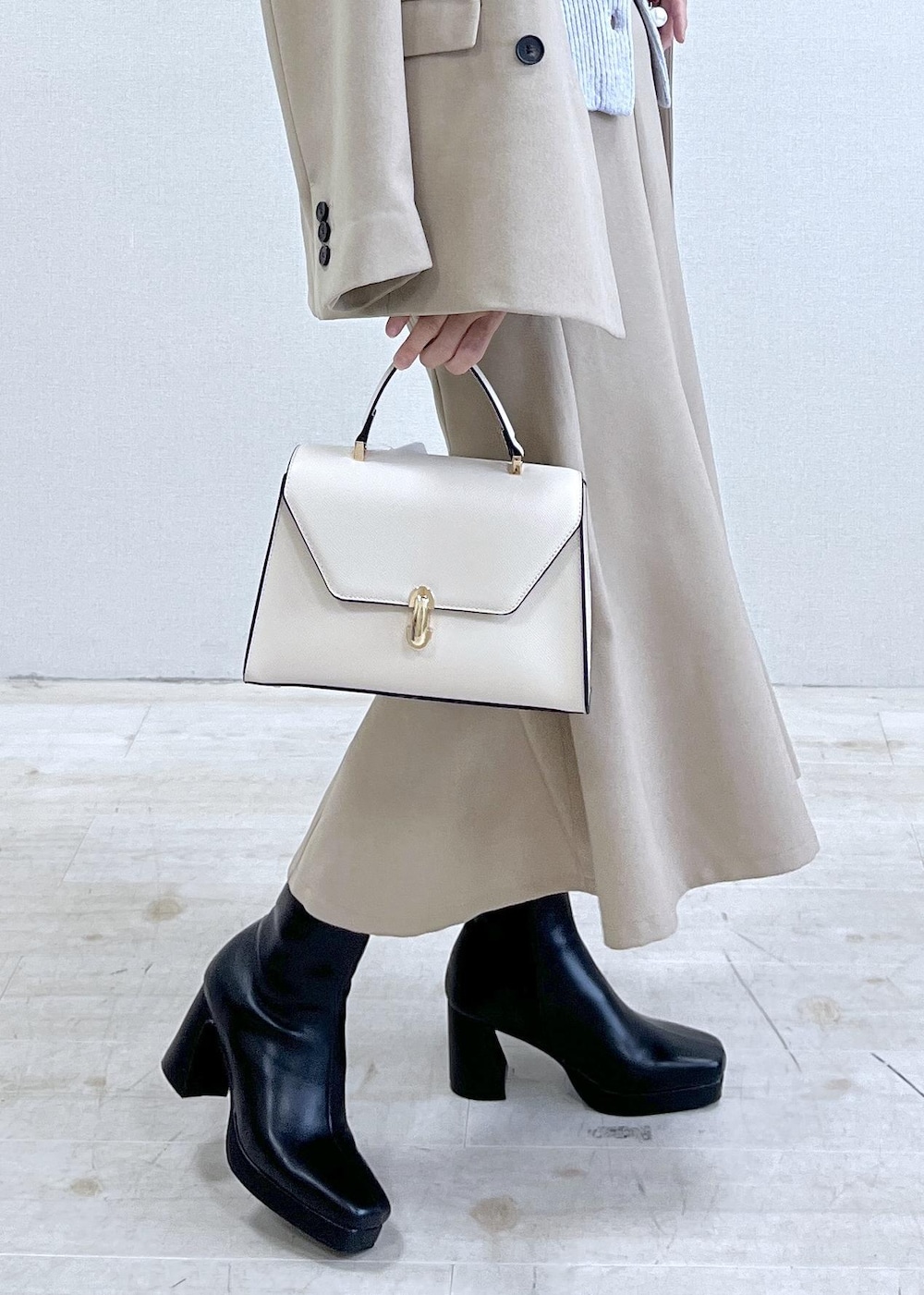 ブラック系のブーツ、ベージュ系のスカート、パープル系のカーディガン/ボレロを着用したレディースの秋コーディネートの7枚目の写真