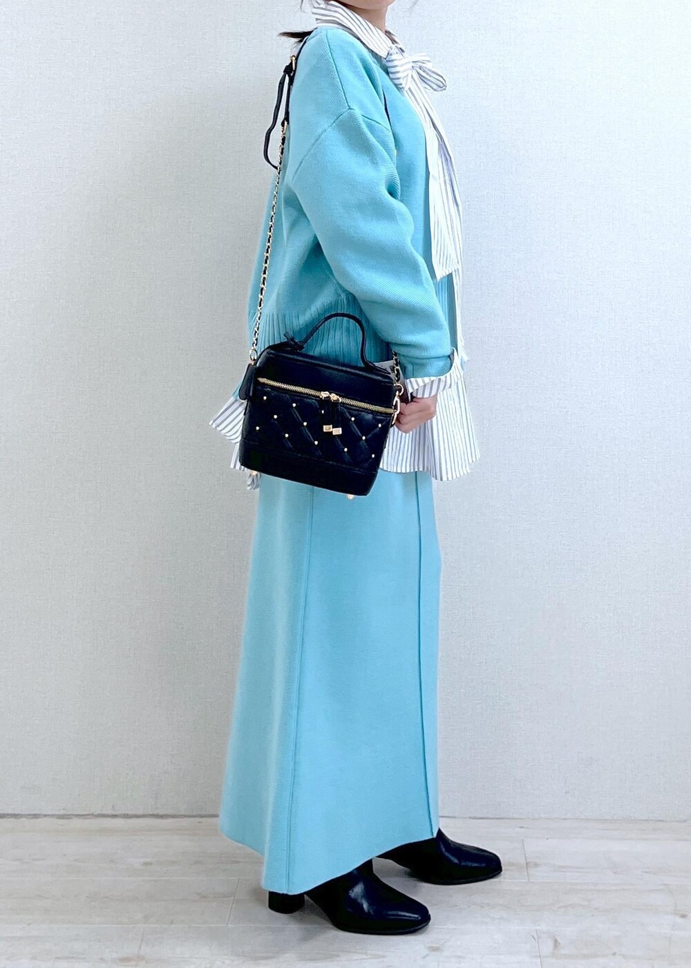 ブラック系のブーツ、ブルー系のスカート、ホワイト系のシャツ/ブラウスを着用したレディースの冬コーディネートの8枚目の写真