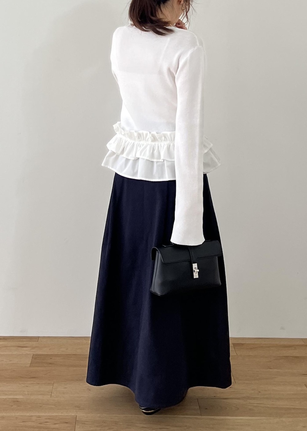 ブラック系のショルダーバッグ、ブラック系のパンプス、ホワイト系のナイロンジャケットを着用したレディースの冬コーディネートの9枚目の写真