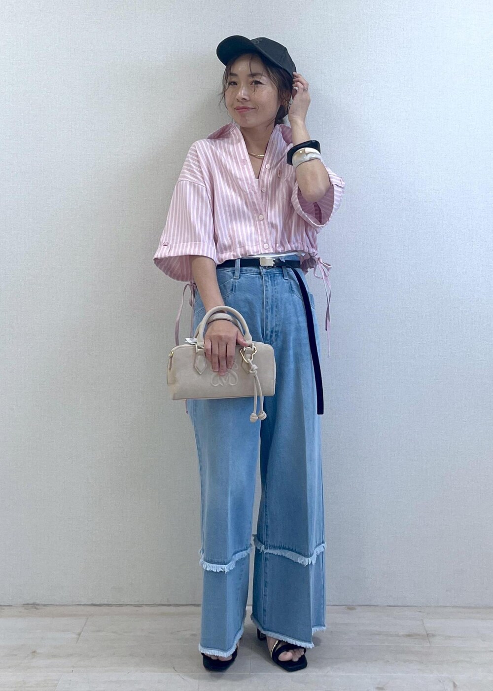 ブラック系のサンダル、ブルー系のデニムパンツ、ベージュ系のボストンバッグを着用したレディースの夏コーディネートの10枚目の写真