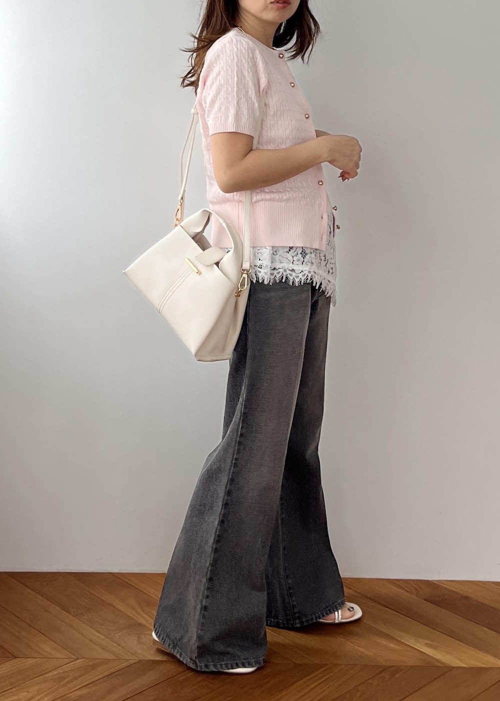 ホワイト系のキャミソール、ブラック系のデニムパンツ、ホワイト系のショルダーバッグを着用したレディースの春コーディネートの4枚目の写真