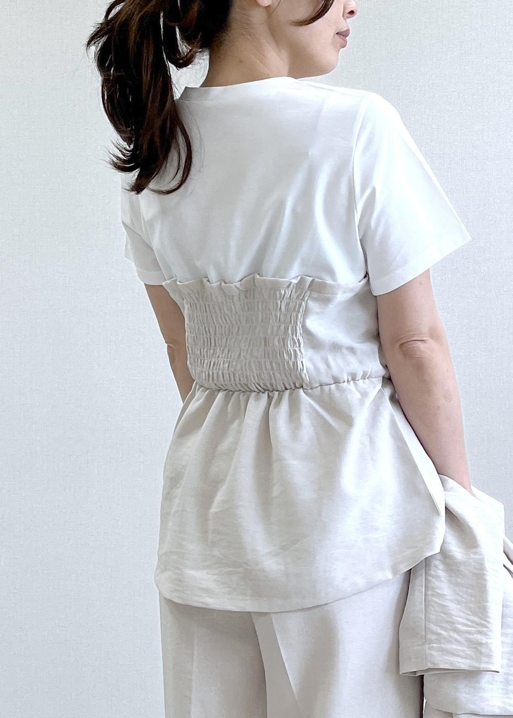 ベージュ系のパンプス、ブラック系のショルダーバッグ、ホワイト系のTシャツ/カットソーを着用したレディースの春コーディネートの9枚目の写真