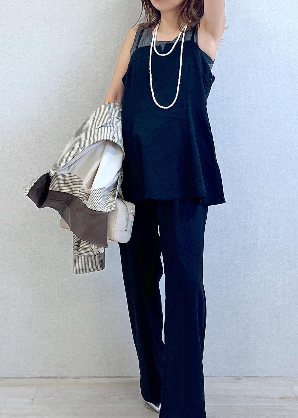 シルバー系のパンプス、ブラック系のキャミソール、ベージュ系のカバーオールを着用したレディースの秋コーディネートの2枚目の写真