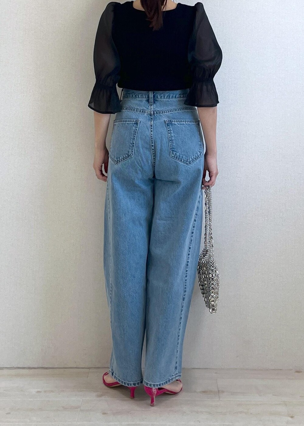 ブラック系のニット/セーター、ブルー系のデニムパンツ、シルバー系のショルダーバッグを着用したレディースの春コーディネートの3枚目の写真