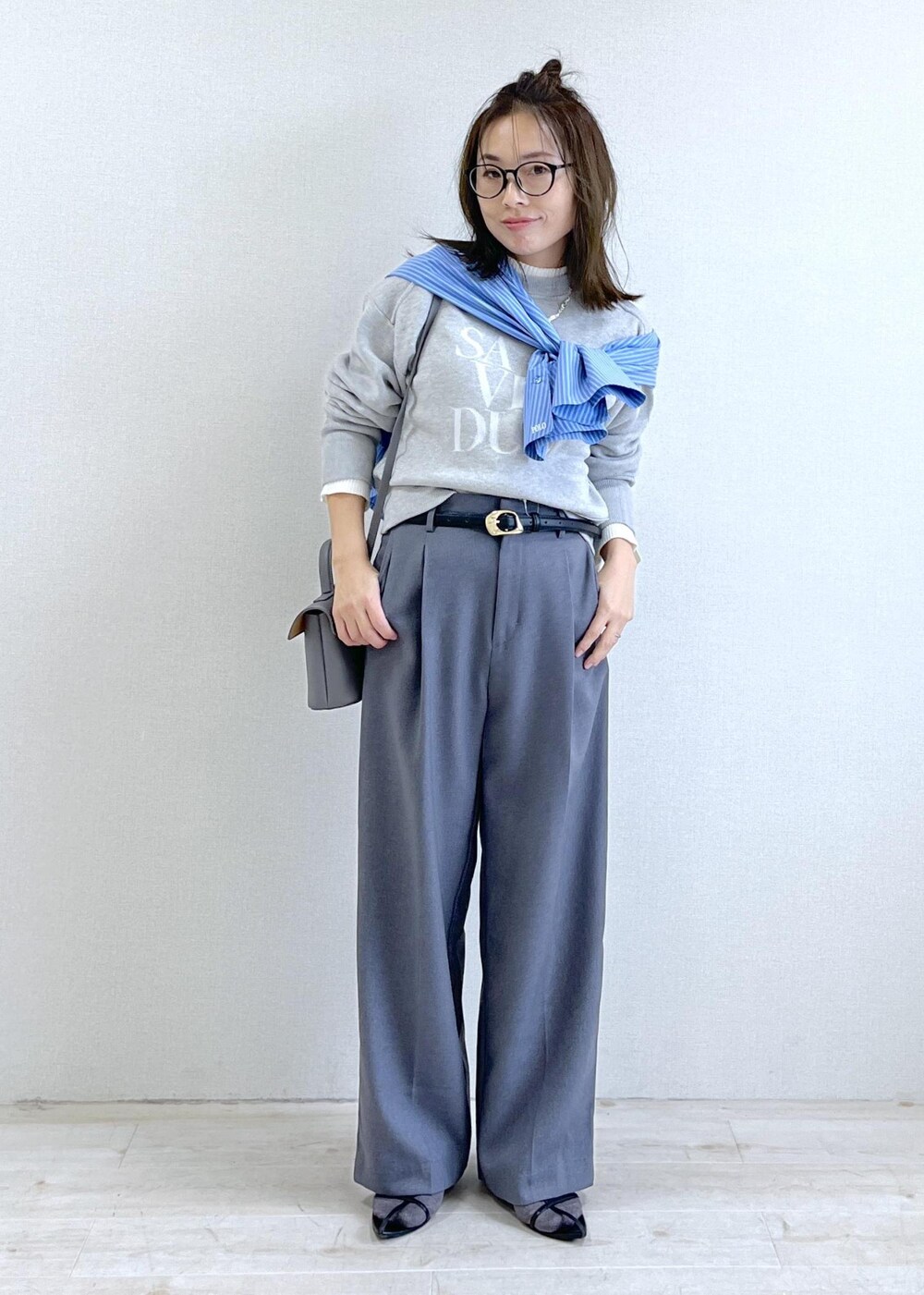 グレー系のショルダーバッグ、グレー系のスラックス、ブルー系のシャツ/ブラウスを着用したレディースの秋コーディネートの8枚目の写真