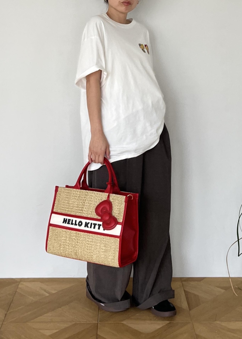 レッド系のトートバッグ、ホワイト系のTシャツ/カットソーを着用したレディースの夏コーディネートの4枚目の写真