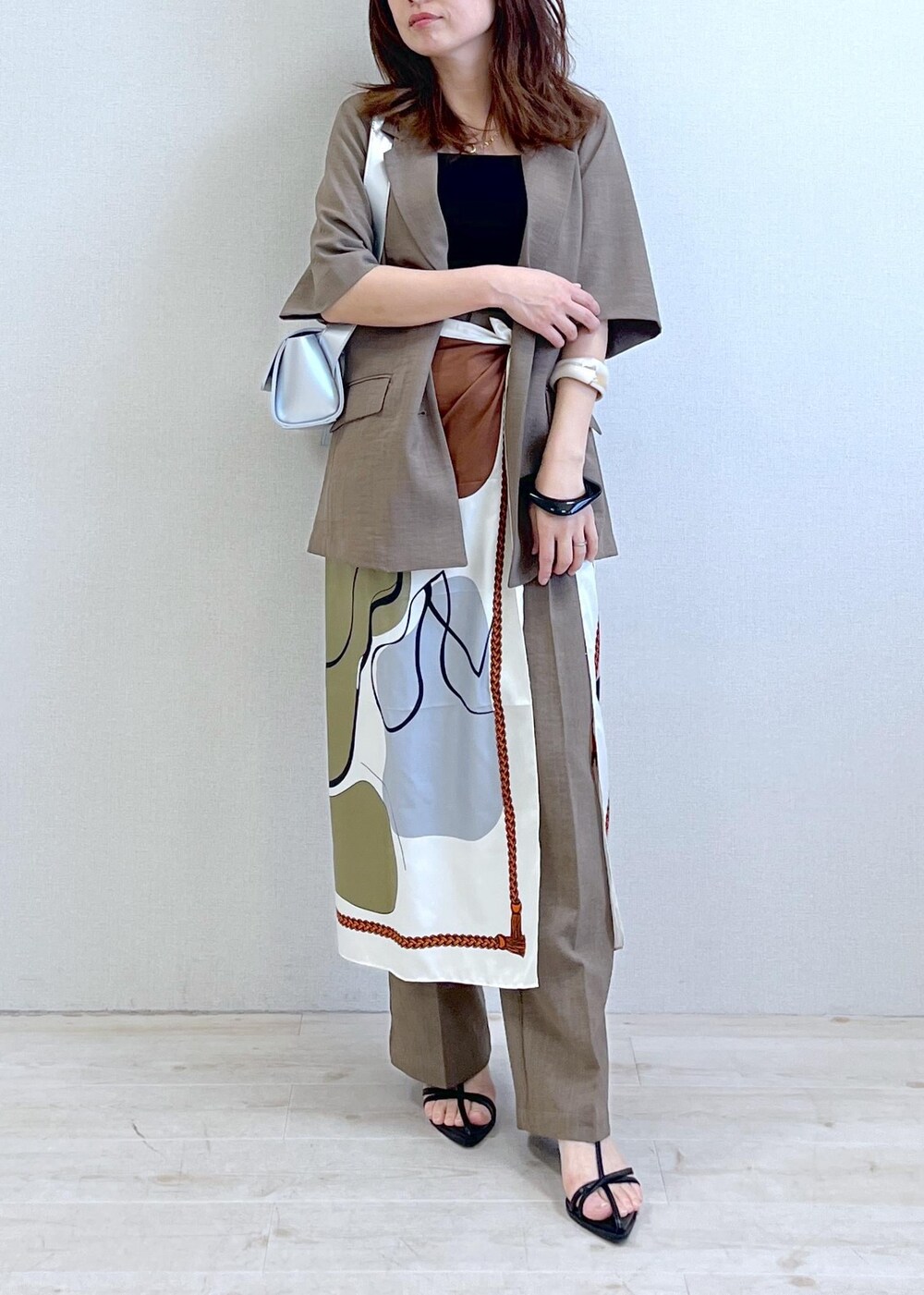 ブラック系のキャミソール、シルバー系のショルダーバッグ、ブラック系のサンダルを着用したレディースの春コーディネートの6枚目の写真