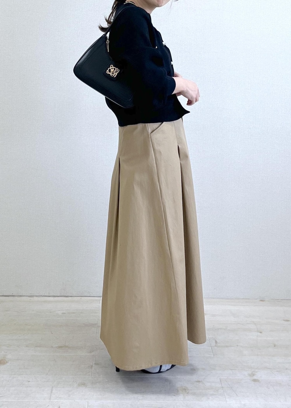 ブラック系のショルダーバッグ、ブラック系のカーディガン/ボレロ、ベージュ系のスカートを着用したレディースの春コーディネートの10枚目の写真